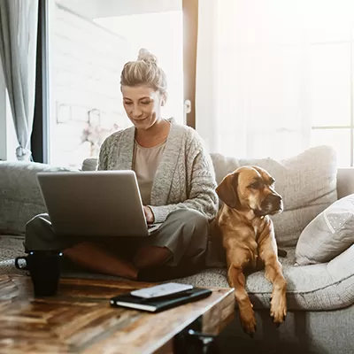 Eine Frau schließt eine Hausierversicherung am Laptop ab